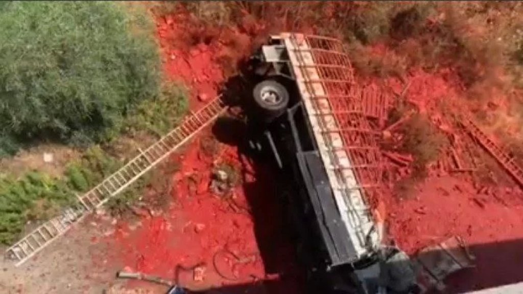 بالفيديو/ سقوط شاحنة محملة بعبوات رب البندورة على جسر الفياضية 